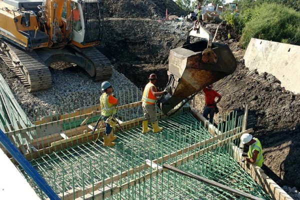 Workers pouring concrete for the tollway